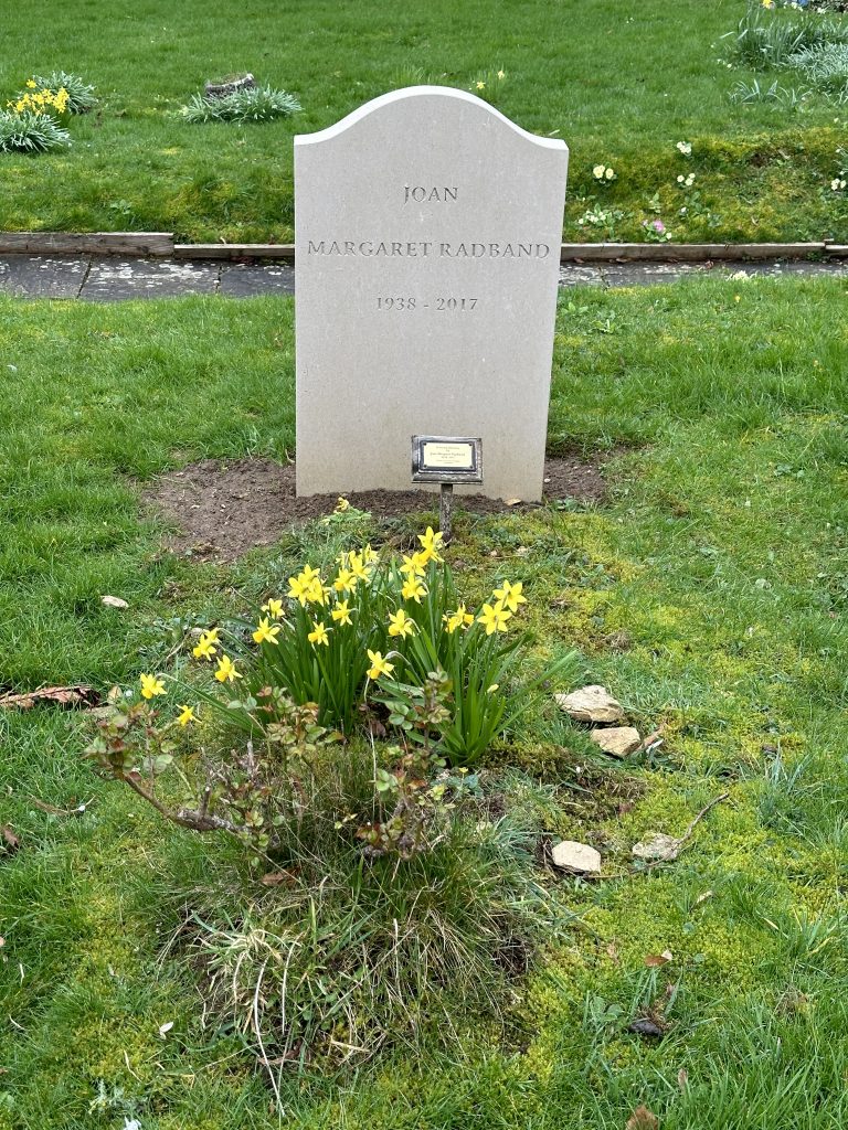 The grave of Joan Margaret Radband (1938-2017) at All Saints Church, Turkdean 2024
